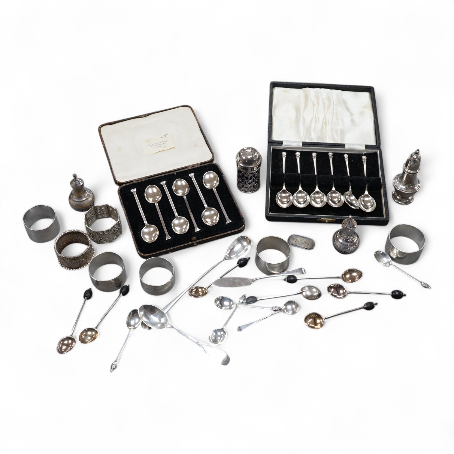 Four assorted silver napkin rings, two cased sets of six silver spoons, four silver condiments including a pair, a small group of sundry flatware, a silver wine label and a plated napkin ring.